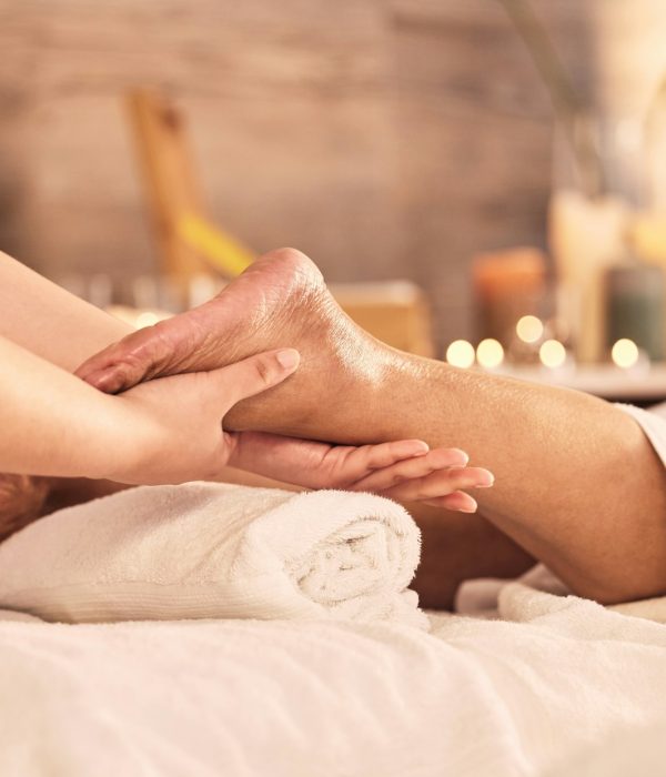 Closeup, foot and relax for massage at spa in acupressure treatment, holistic therapy or healing de